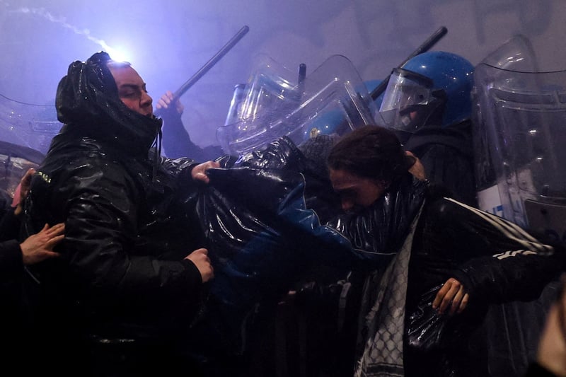 Police fire water cannon at protesters hurling smoke bombs in Olympic host Milan